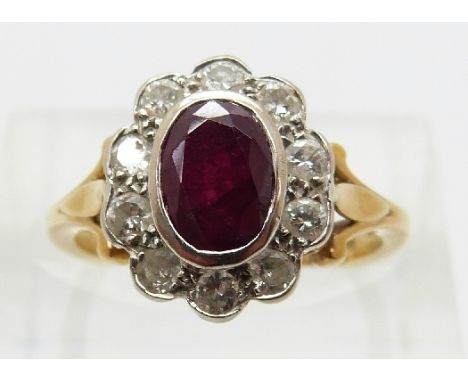 An 18ct gold ring set with an oval cut ruby of approximately 1ct surrounded by round cut diamonds, each approximately 0.04, s