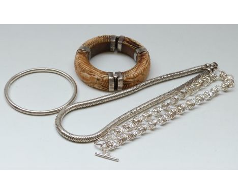 A carved bone bangle depicting an elephant with white metal fittings, silver flapper bangle and a heavy silver necklace 