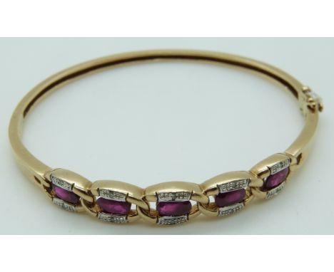 A 9ct gold bangle set with five oval cut rubies and diamonds, 12.4g  
