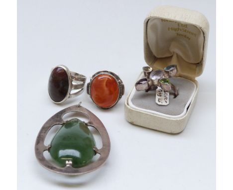 A large silver pendant set with a pear shaped nephrite jade cabochon, two silver rings set with agate and a silver ring set w