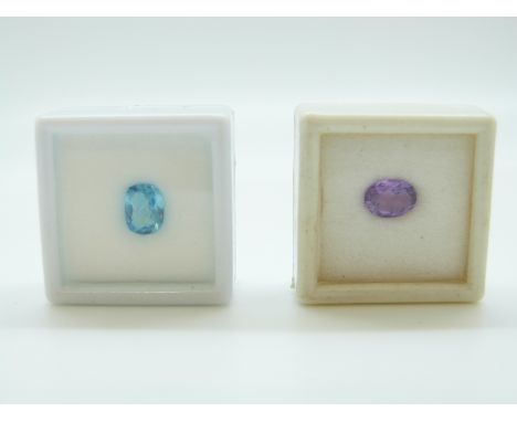 A blue mixed cut topaz, an oval cut amethyst, an emerald cut emerald and a ruby cabochon