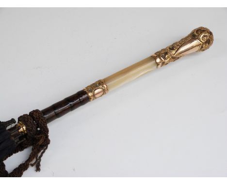 A late 19thC/20thC parasol with mother-of-pearl and yellow metal repoussé decorated handle with vacant cartouche, yellow meta