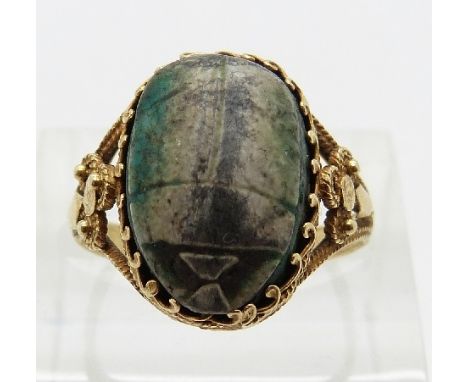 A 19thC yellow metal Egyptian ring set with a ceramic scarab beetle, size N