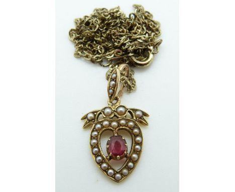 An Edwardian 15ct gold pendant set with a ruby and seed pearls in a heart shape
