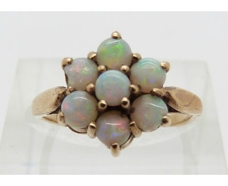 A 9ct gold ring set with a cluster of opal cabochons, size K