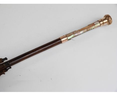 A late 19thC/20thC parasol with 15ct gold handle and collar and hardwood stick, 89cm