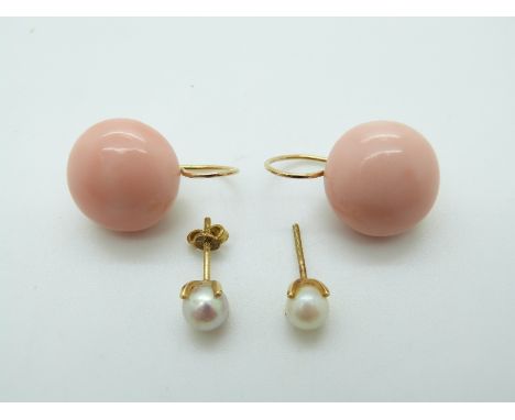 A pair of 18ct gold earrings set with a pearl to each and a pair of yellow metal earrings each set with a large coral cabocho