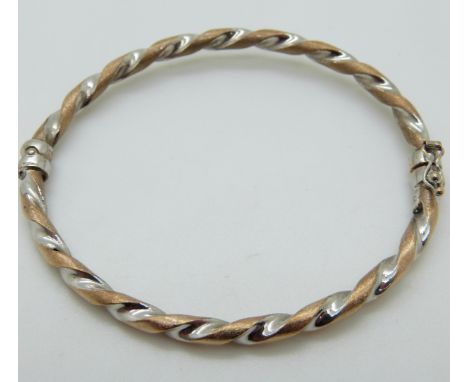 A 9ct bi-coloured gold bangle, 5.2g