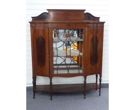 Edwardian inlaid mahogany display cabinet with glazed central door flanked by serpentine fronted cupboards all with shelf bel