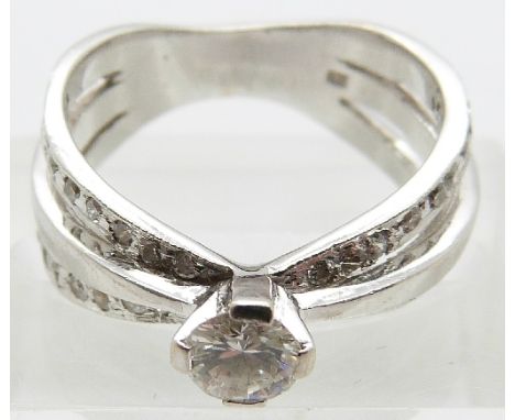 A 14ct white gold ring set with a round brilliant cut diamond of approximately 0.33ct and further diamonds to the shoulders, 