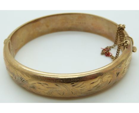 A 9ct gold bangle with engraved foliate decoration, 18.8g