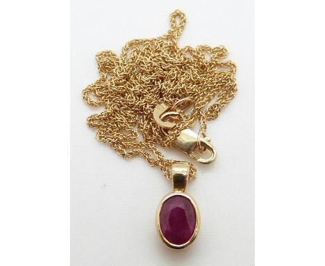 A 9ct gold pendant set with an oval ruby on a 9ct gold chain, 3.4g