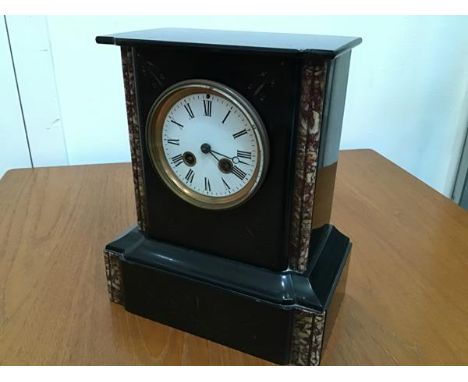 A 19thc black slate and marble mounted mantel clock with enamelled dial and twin key apertures, with engraved decoration (28c