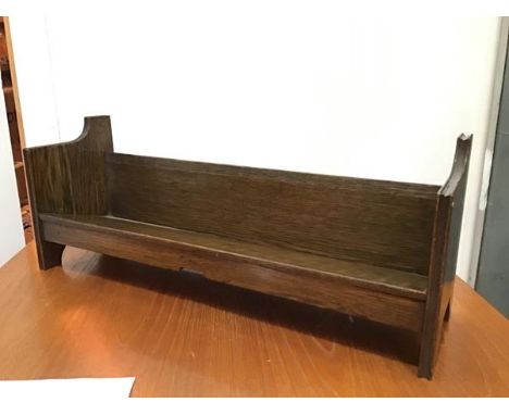 A 1930s oak book trough of V shaped form, raised on shaped end supports (25cm x 64cm x 18cm)