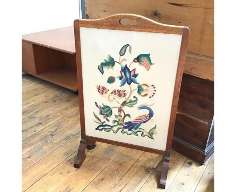 A 1930s oak framed firescreen, with embroidered panel depicting flowers, leaves and birds (80cm x 49cm x 25cm)