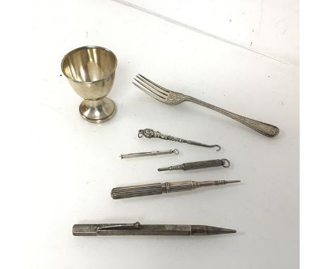 A Victorian London silver fork, an Edwardian Birmingham silver egg cup (combined: 58.54g), together with three mechanical pen