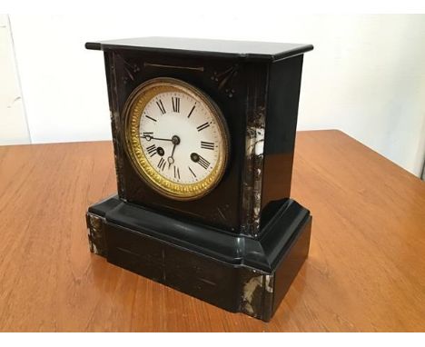 A 19thc black slate and marble mounted mantel clock, with enamelled dial and twin key apertures, with roman numerals, on moul