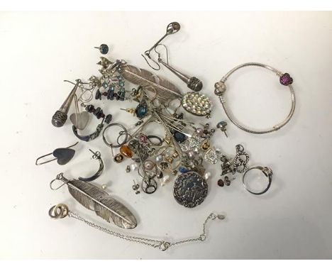 An assortment of silver and costume jewellery including silver feather earrings, silver button with Classical scene, a chain,