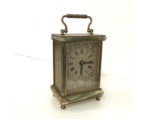 A carriage clock with onyx top and base, with gilt metal mounts, the dial with roman numerals surrounded by C scrolls, batter