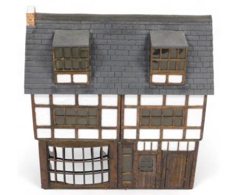 A Tudor style doll's house, of three floors, with five rooms, 68cm x 69cm, together with assorted doll's house furniture and 