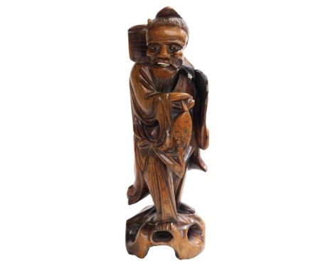 A 19thC Qing dynasty Chinese hardwood carving of a fisherman with his catch, with silver wire inlays, bone inlaid teeth, 30cm