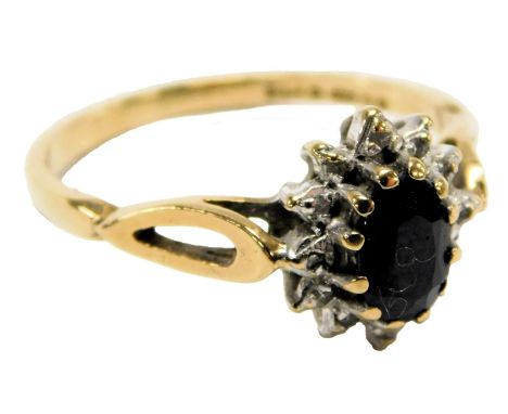 A 9ct gold sapphire and diamond ring, the oval cut sapphire in a surround of diamonds, size K½, 1.6g.