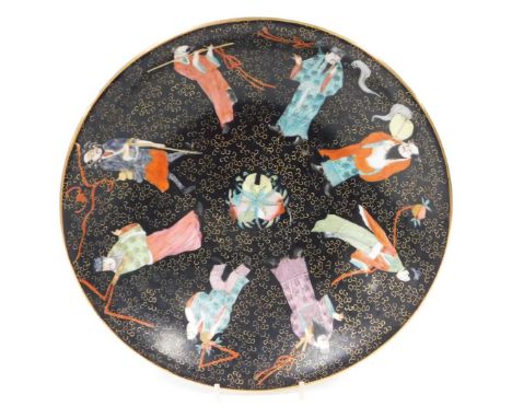 An early 20thC Chinese porcelain dish, decorated with peaches and The Eight Immortals, on a black ground, six character Qianl