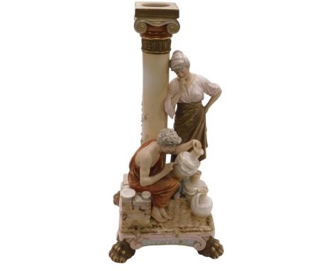 A Royal Dux porcelain figural candlestick, with a doric column, flanked by a lady pondering over a man decorating an amphora,