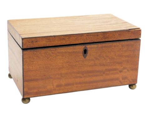 A Georgian mahogany tea caddy, of rectangular section, the hinged lid opening to reveal a twin lidded compartment, raised on 