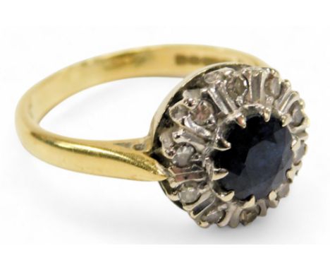 An 18ct gold sapphire and diamond flower head ring, the circular cut sapphire in a surround of tiny diamonds, size K½, 3.7g.