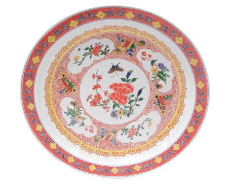 A 20thC Chinese porcelain charger, with butterfly and blossom central reserve enclosed by floral cartouches and precious obje