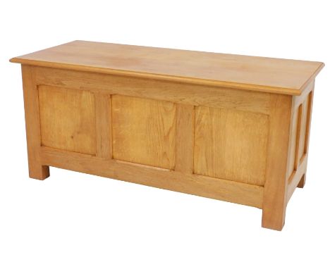 An oak coffer by Michael Griffin, with a triple panelled front, raised on stiles, 56cm high, 122cm wide, 51cm deep.