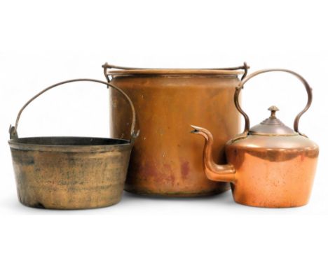 An early 20thC copper log bucket, with cast iron swing handles, 28cm high, jam pan, and a copper kettle. (3)