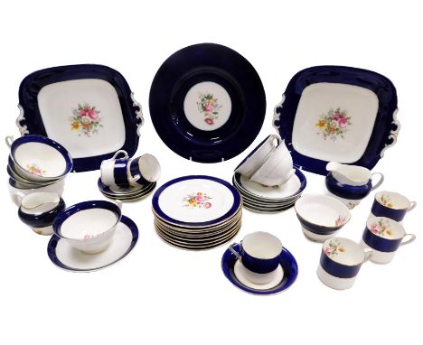 An early 20thC porcelain demitasse coffee service, decorated with flowers, within a cobalt blue border, comprising cream jug,