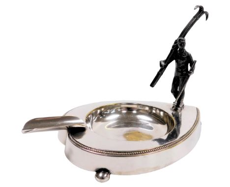 An early 20thC WMF silver plated ashtray, of playing card spade form, surmounted with a figure of a skier holding his skis an