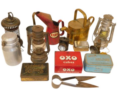 A group of paraffin lamps and heaters, an Esso quart oil jug, brass watering can, measures and advertising tins, etc. (a quan