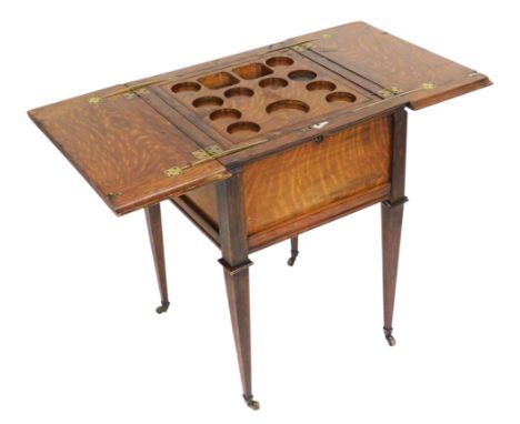 An Edwardian oak drinks cabinet, of square section, the double hinged lidded top, opening to reveal a lift up tray with reces