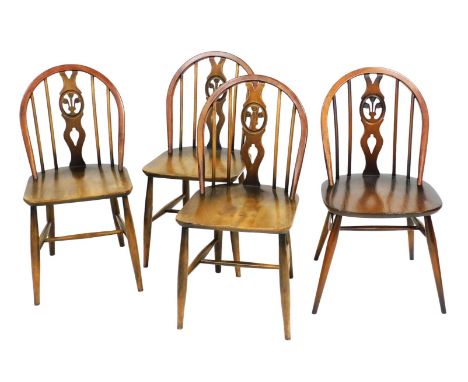 A set of four Ercol dark elm and beech fleur de lys dining chairs. 