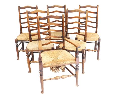 A set of six oak ladder back and rush seated dining chairs, including a carver.