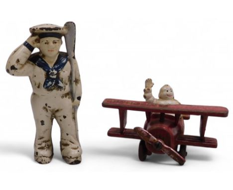 A vintage Michelin cast iron man in a biplane advertising figure, 13cm wide, together with a cast iron money box, modelled as