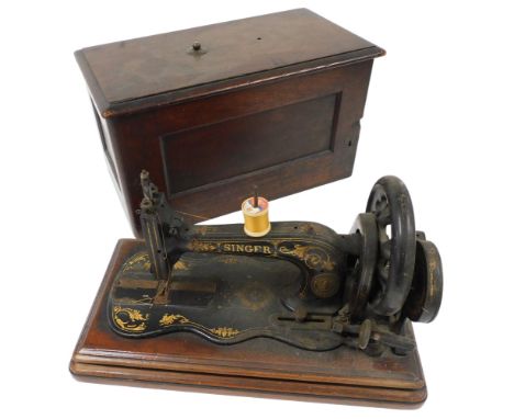 A Singer hand operated sewing machine, in a partial case.