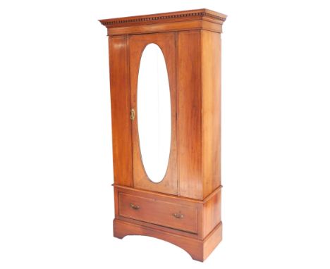 An Edwardian mahogany single wardrobe, with satinwood cross banding, the outswept pediment with dentil moulding, above a cent