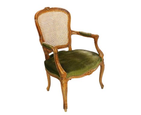 A French 19thC style oak carver chair, with a cane back, overstuffed seat, raised on cabriole legs, 62cm wide.