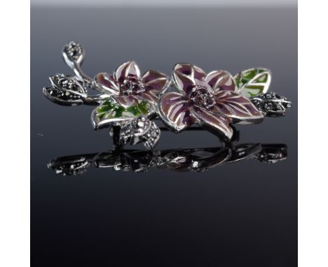 Charming vintage brooch by Monet, crafted in silver tone metal and shaped as a twin-flower spray. The piece is adorned with r