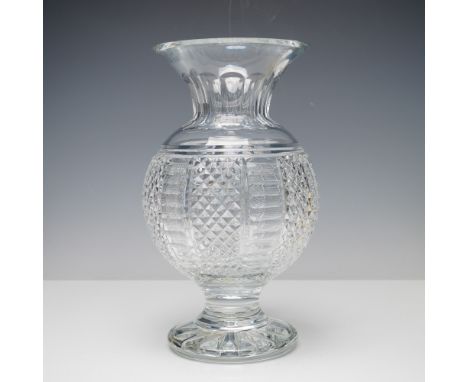 A bulbous body with alternating panels of deep cross-hatch and vertical thumbprint cuts. The design is complemented by a flar
