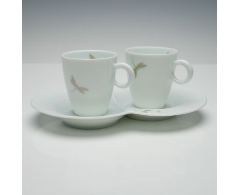 Three-piece porcelain tea set gifted by Van Cleef &amp; Arpels, featuring two matching cups and a dual-well saucer. Each cup 