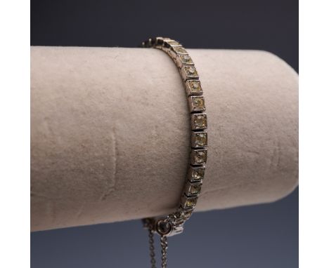 This vintage sterling silver bracelet is marked OTIS STERLING and showcases a classic line of round-cut clear stones set in s