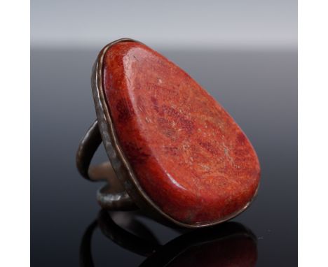 This handcrafted statement ring features a bold red jasper cabochon with warm orange undertones and natural patterning, polis