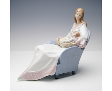 The glazed sculpture depicts a serene maternal scene featuring a young woman seated in a textured pastel blue armchair, holdi