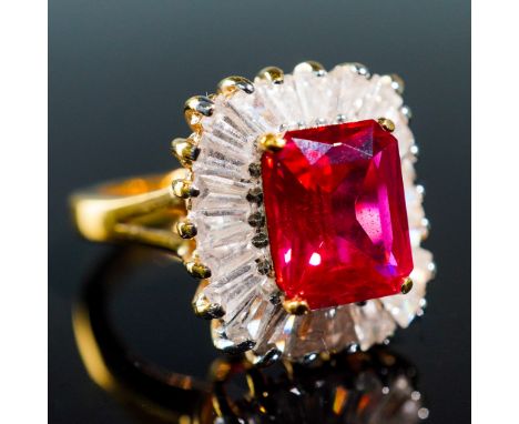 This elegant ladies ring features a vibrant lab-created ruby, complemented by shimmering CZ baguettes for a striking contrast